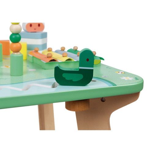 Un adorable bébé joue avec des jouets à table. L'enfant pousse la